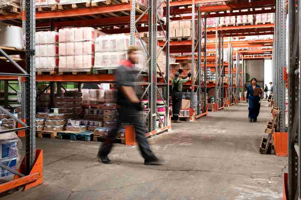 A person walking infront of heavy duty racks in a warehouse (illustrtation)
